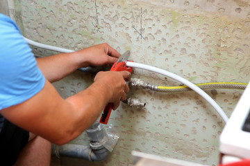 The plumber assembles a new water connection to the sink.
