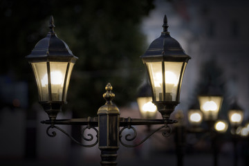 Fototapeta na wymiar Black street lamp against a blue evening sky.