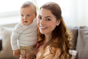 happy young mother with little baby at home