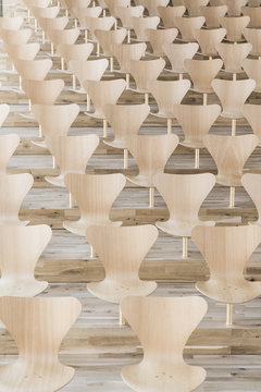 Diagonal symmetrical rows of designer wooden chairs