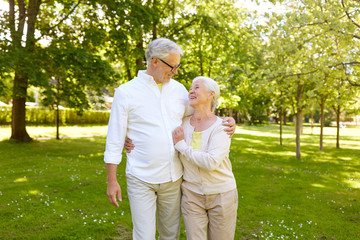 happy senior couple hugging in city park