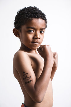 Portrait of a boy with a funny tattoo on biceps.