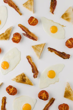 Graphic Background With Fried Egg, Bacon, Tomato And Toast, Overhead On White