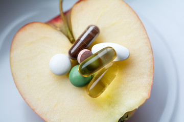 Nahrungsergänzung - Pillen,Tabletten und Kapseln auf einem Apfel
