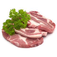 Raw pork neck chop meat with parsley herb leaves garnish isolated on white background cutout