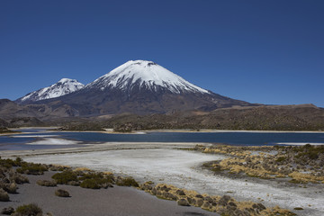 Volcanoes Parinacota and Pomerape in Lauca National Park high on the Altiplano of northern Chile. In the foreground lakes known as Lagunas de Cotacani