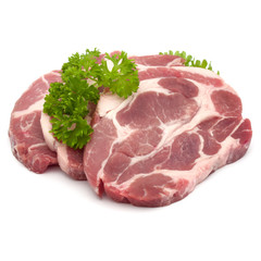 Raw pork neck chop meat with parsley herb leaves garnish isolated on white background cutout
