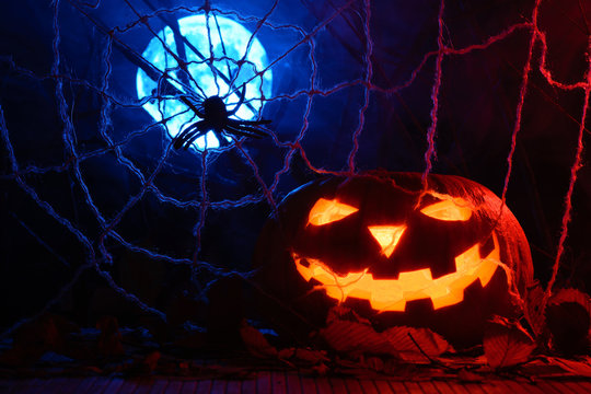 Horrible Halloween pumpkin in the background of the web and the full moon