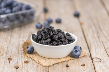 Portion of Dried Blueberries on wooden background, selective focus
