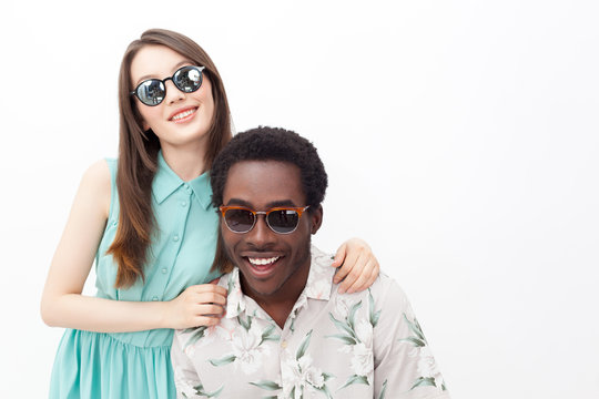 Smiling mixed couple in sunglasses
