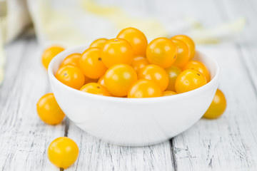 Wooden table with Yellow Tomatoes, selective focus