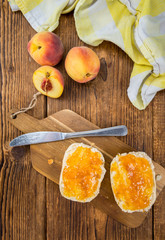 Peach Jam on wooden background; selective focus