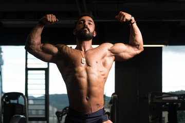 Obraz na płótnie Canvas Bodybuilder Fitness Model Posing Double Biceps After Exercises
