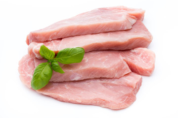 Fresh pork fillet with basil on a white background.