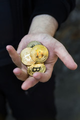 Golden bitcoins in a hand