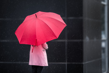 Girl in Pink with red Umbrella on rainy day
