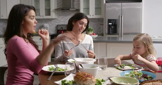 Female gay couple and daughter having dinner in their kitchen, shot on R3D