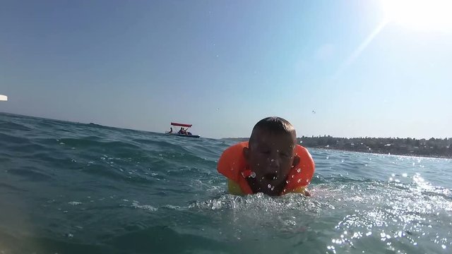 family vacation boy on pedal boat pulls off the hill into the sea, view from water
