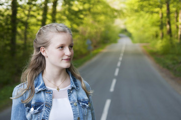 Portrait of a cute teenage girl outdoor standing on the road close-up