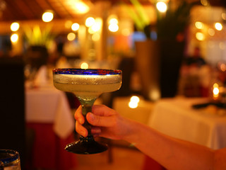 Glass of cold margarita in a woman's hand