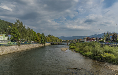 Fototapeta na wymiar Vah river in Ruzomberok town with cloudy blue sky