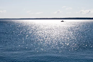 Poster Im Rahmen Silhouette of a boat in a sunny reflection in Lake Superior © karagrubis