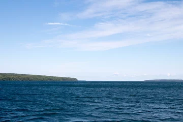 Ingelijste posters Blue water of Lake Superior and a green Apostle Island © karagrubis