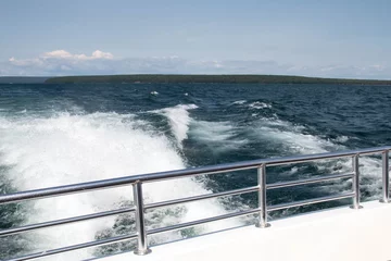 Rolgordijnen Wake of a boat behind a deck railing on Lake Superior  © karagrubis