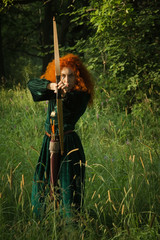Red haired girl shoots from the bow