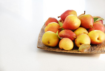 Juicy pears on the wooden plate on the white background