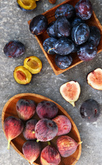 Fresh plums and figs on the wooden plates