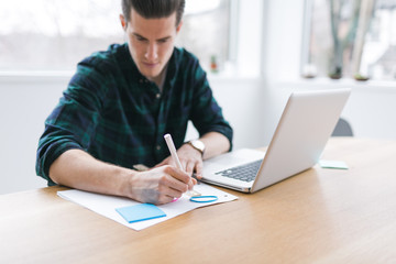 Young man studying with a laptop