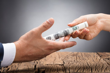 Businessperson Giving Bribe To Partner