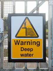 close up yellow sign at dock warning deep water