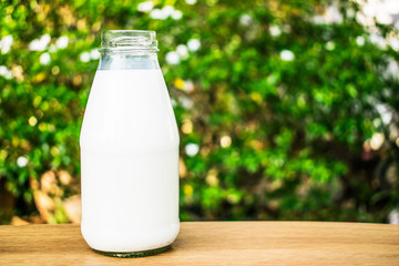 A bottle of milk on wood table.