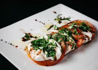 Caprese Salad on a white plate with dark background