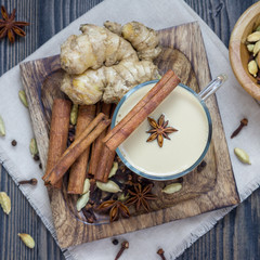 Masala chai with spices on wooden background, square format, top view