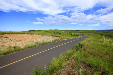 asphalt road on grassland