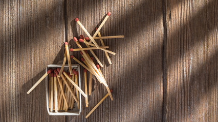 matchsticks and matchbox on the wooden table under morning light beam