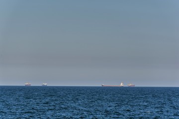  Large cargo ships waiting to be loaded or unloaded in offshore. Large containers ship or tanker on horizon in Black Sea.