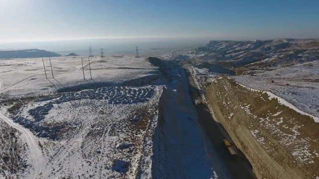 Aerial view of three suvs moving along the highway in the desert in winter. Western Kazakhstan, Mangyshlak Peninsula.