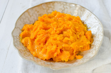 Pumpkin puree in a plate on a wooden table