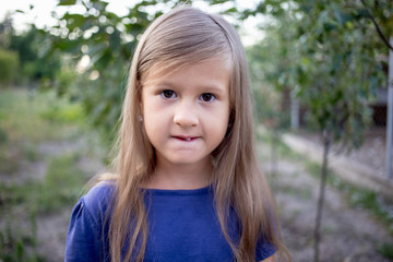 Young little girl without a front tooth in the countryside