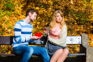 Man confess love to girl on bench in park.