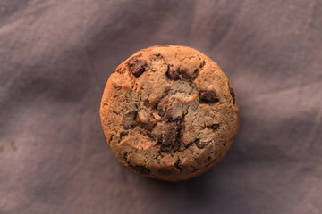 Stack of chocolate chips cookies on brown background