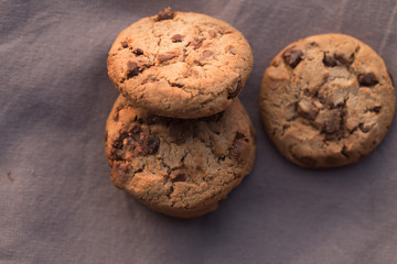 Stack of chocolate chips cookies on brown background