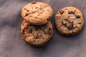 Stack of chocolate chips cookies on brown background
