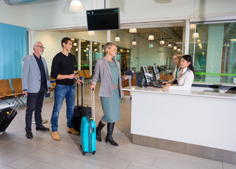 Passengers With Luggage Waiting At Airport Reception