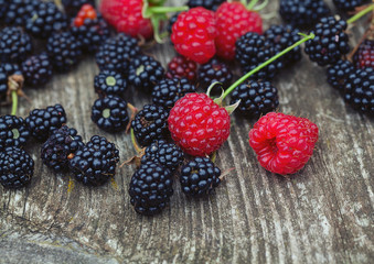 fresh raspberries and blackberries on eustic wooden surface
