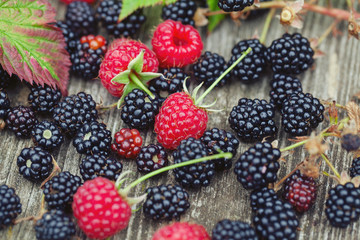 fresh raspberries and blackberries on eustic wooden surface
